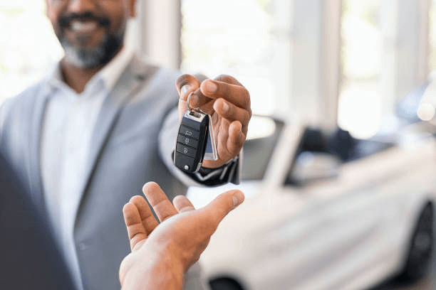 salesman-giving-new-car-keys-to.png